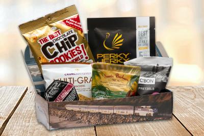 Donated Pacific Surfliner snack packs include turkey jerky, Asiago cheese spread, multigrain mini pretzels, trail mix, chocolate chip cookies, and a peppermint taffy.